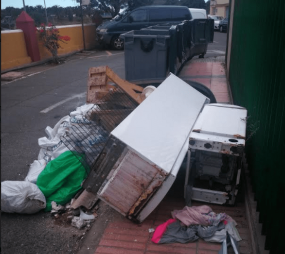 Basura, enseres, escombros y electrodomésticos viejos bloquean el paso por la acera.